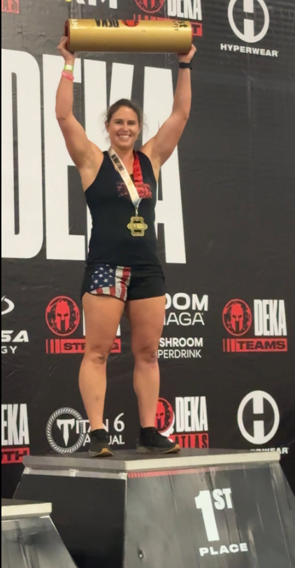 SemperFit athlete celebrating first place on the DEKA podium