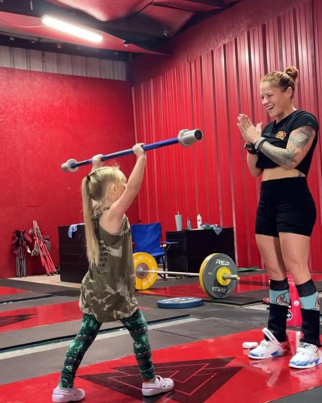 Youth lifter with coach on the platform