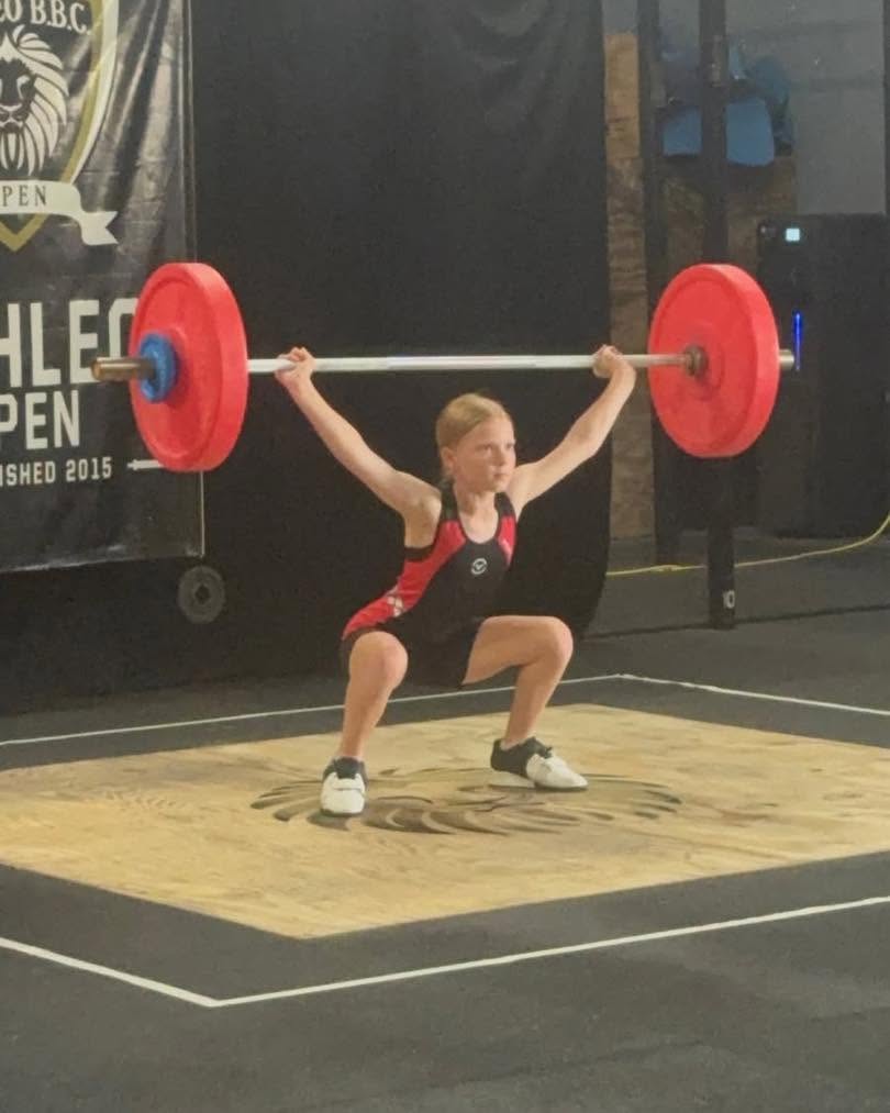 Youth lifter overhead in the snatch